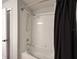 Bathtub and shower combo with chrome fixtures and a dark shower curtain at 295 Whirlaway Drive, Davenport, FL 33837