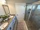 Bathroom featuring double sinks, granite countertop, and shower with glass door at 295 Whirlaway Drive, Davenport, FL 33837