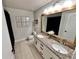 Bathroom featuring double sinks, granite countertop, and framed mirror at 295 Whirlaway Drive, Davenport, FL 33837