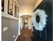 Inviting entryway with wood-look floors, neutral paint, and a decorative wreath on the black front door at 295 Whirlaway Drive, Davenport, FL 33837