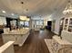 Open-concept living room and kitchen space with hardwood floors and modern lighting fixtures at 295 Whirlaway Drive, Davenport, FL 33837