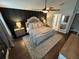 Relaxing main bedroom showcasing a luxurious king bed, dark wood floors, ceiling fan, and a decorative rug at 295 Whirlaway Drive, Davenport, FL 33837
