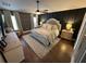 Comfortable main bedroom featuring a king bed, ceiling fan, stylish wallpaper, and matching nightstands with lamps at 295 Whirlaway Drive, Davenport, FL 33837