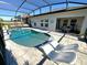 Backyard featuring a screened pool and spa with poolside lounge chairs, complemented by modern patio design at 295 Whirlaway Drive, Davenport, FL 33837