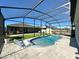 Inviting pool area with sleek lounge chairs, enclosed by a screened lanai with comfortable seating at 295 Whirlaway Drive, Davenport, FL 33837