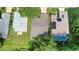Aerial view of a well-maintained home with mature trees, a garden, and a sparkling backyard pool at 32942 Rambling Oaks Ct, Leesburg, FL 34748