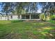 The backyard has a well maintained lawn with mature trees and landscaping at 32942 Rambling Oaks Ct, Leesburg, FL 34748