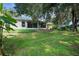A well-maintained yard with green grass and mature trees surrounding the home at 32942 Rambling Oaks Ct, Leesburg, FL 34748