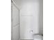 Bathroom with an enclosed shower with a glass door and toilet with a toilet paper holder on the wall at 32942 Rambling Oaks Ct, Leesburg, FL 34748