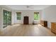 Bright bedroom with hardwood floors, windows, and sliding doors leading to outdoor space and a ceiling fan at 32942 Rambling Oaks Ct, Leesburg, FL 34748