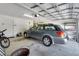 Clean, well-organized garage with a car parked inside and plenty of room for storage, plus a bicycle at 32942 Rambling Oaks Ct, Leesburg, FL 34748