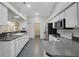 Open kitchen layout with white cabinets, granite counters, and stainless steel appliances at 32942 Rambling Oaks Ct, Leesburg, FL 34748