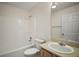 Bathroom with a combined shower and tub, vanity with sink, and a mirrored wall at 3393 Woodridge Dr, The Villages, FL 32162