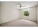 Bright bedroom with a ceiling fan, carpet, and a window view of lush trees at 3393 Woodridge Dr, The Villages, FL 32162