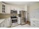 Well-lit kitchen featuring stainless steel appliances and bright, white cabinetry at 3393 Woodridge Dr, The Villages, FL 32162