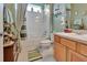 Cozy bathroom featuring a shower-tub combo, wood vanity, and decorative accents at 3507 Arlington Ridge Blvd, Leesburg, FL 34748