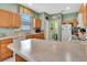 Open kitchen with breakfast bar, wood cabinetry, and a view of the adjacent laundry room at 3507 Arlington Ridge Blvd, Leesburg, FL 34748