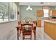 Sunny kitchen featuring a wooden table, wood cabinets, and large window with natural light at 3507 Arlington Ridge Blvd, Leesburg, FL 34748