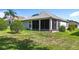 Well-maintained backyard featuring a screened in lanai, lush grass, and manicured landscaping at 3601 Mount Hope Loop, Leesburg, FL 34748