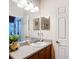 Bathroom sink with a wooden cabinet, vanity mirror and white door to the side at 3601 Mount Hope Loop, Leesburg, FL 34748