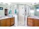 Bathroom with glass enclosed shower between two wood vanities, each with a gray countertop at 3601 Mount Hope Loop, Leesburg, FL 34748