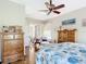 Spacious bedroom with hardwood floors, wooden dressers, and a comfortable seating area at 3601 Mount Hope Loop, Leesburg, FL 34748