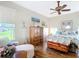 Bright bedroom with wood furnishings and a cozy seating area by the window at 3601 Mount Hope Loop, Leesburg, FL 34748