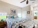 Light-filled bedroom featuring a queen-sized bed with sea-themed bedding and en-suite bathroom at 3601 Mount Hope Loop, Leesburg, FL 34748