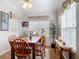Bright dining area with wood table, chairs, and large windows adorned with floral valances at 3601 Mount Hope Loop, Leesburg, FL 34748