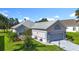 Charming home with a two-car garage, well-manicured lawn, and inviting landscaping, offering great curb appeal at 3601 Mount Hope Loop, Leesburg, FL 34748