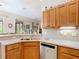 Kitchen with a stainless steel dishwasher and sink, next to wood cabinets at 3601 Mount Hope Loop, Leesburg, FL 34748