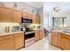 Kitchen featuring light wood cabinets, granite countertops, and modern appliances at 3601 Mount Hope Loop, Leesburg, FL 34748