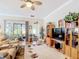 Open concept living room featuring ceiling fan, access to lanai, and entertainment center for relaxation and leisure at 3601 Mount Hope Loop, Leesburg, FL 34748