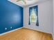Cozy bedroom featuring wood-look flooring, light walls and a bright window with curtains at 3677 Serena Ln, Clermont, FL 34711