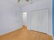 Bedroom featuring wood-look flooring, closet with white doors and a doorway to another room at 3677 Serena Ln, Clermont, FL 34711