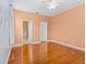Bedroom featuring hardwood floors, a ceiling fan, ensuite bathroom and a white door at 3677 Serena Ln, Clermont, FL 34711