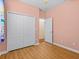 Bedroom with wood-look flooring, double closet with white doors and a door to another room at 3677 Serena Ln, Clermont, FL 34711