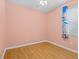 A simple bedroom with wood-look flooring, ceiling fan, and a window with light-blocking curtains at 3677 Serena Ln, Clermont, FL 34711