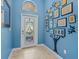 Foyer with blue accent wall adorned with black framed art pieces arranged in the shape of a Gathering tree at 3677 Serena Ln, Clermont, FL 34711