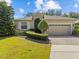 Charming single-story home with a well-manicured lawn, mature landscaping, and a brick driveway at 3677 Serena Ln, Clermont, FL 34711