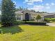 Charming single-story home with a well-manicured lawn, mature landscaping, and a brick driveway at 3677 Serena Ln, Clermont, FL 34711