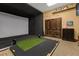 Golf simulator with projector screen and artificial turf, ideal for improving your swing at 3677 Serena Ln, Clermont, FL 34711