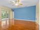 Bright, spacious living room with shiny hardwood floors, ceiling fan, and sliding doors to screened patio at 3677 Serena Ln, Clermont, FL 34711