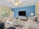Bright living room with neutral furniture, a ceiling fan, and large windows with views of the backyard at 3677 Serena Ln, Clermont, FL 34711