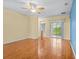 Sunlit main bedroom with beautiful hardwood floors, ceiling fan and access to an ensuite bathroom at 3677 Serena Ln, Clermont, FL 34711