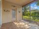 Inviting screened lanai with neutral tile, an exterior door, and views of the surrounding greenery at 3677 Serena Ln, Clermont, FL 34711