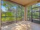 Outdoor patio with tile flooring and screened enclosure overlooking lush landscaping and backyard at 3677 Serena Ln, Clermont, FL 34711