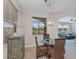 Cozy dining area with woven chairs, a modern light fixture, and a large window overlooking the outdoors at 3681 Arlington Ridge Blvd, Leesburg, FL 34748