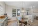 Cozy dining room features a rustic round table and abundant natural light from large window at 3681 Arlington Ridge Blvd, Leesburg, FL 34748