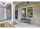 Inviting front porch features a charming bench and decorative columns for a welcoming touch at 3681 Arlington Ridge Blvd, Leesburg, FL 34748